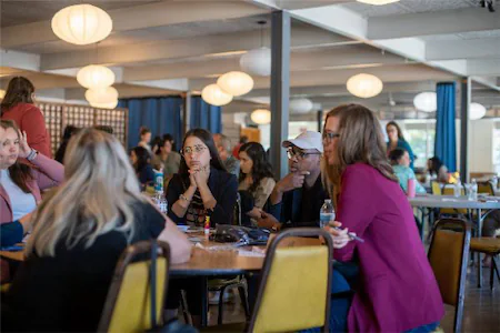 People collaborating in a modern open office space, engaging in group discussions and teamwork.