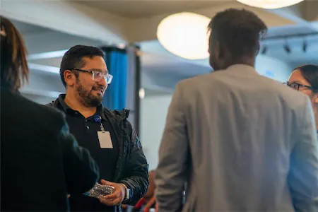 People engaged in conversation at a professional networking event, exchanging ideas and building connections.