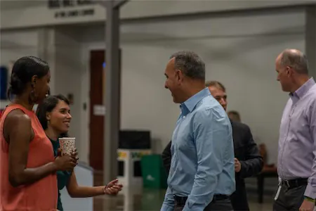 Group of colleagues having a casual conversation in an office setting.