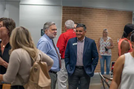 People networking at a conference, engaged in conversation and socializing in a casual setting.