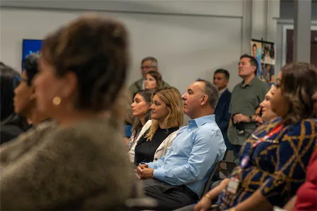 Audience attentively listens during a seminar in a conference room, highlighting engagement and focus.
