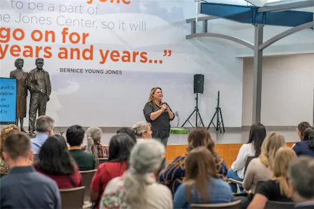 Speaker addressing an audience at the Jones Center, with a quote by Bernice Young Jones displayed on the wall.