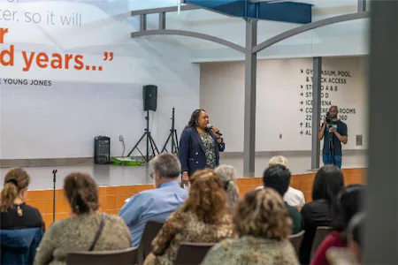 Speaker presenting to an engaged audience in a modern conference setting.