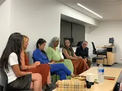 Panel discussion with diverse participants seated in a modern conference room, engaging in conversation.