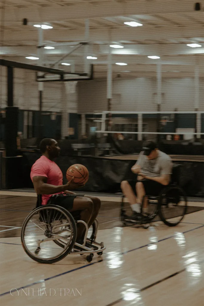 Wheelchair basketball players in action on a court, showcasing athleticism and teamwork.