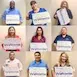 Nine people holding Volunteer signs, promoting community involvement and service.